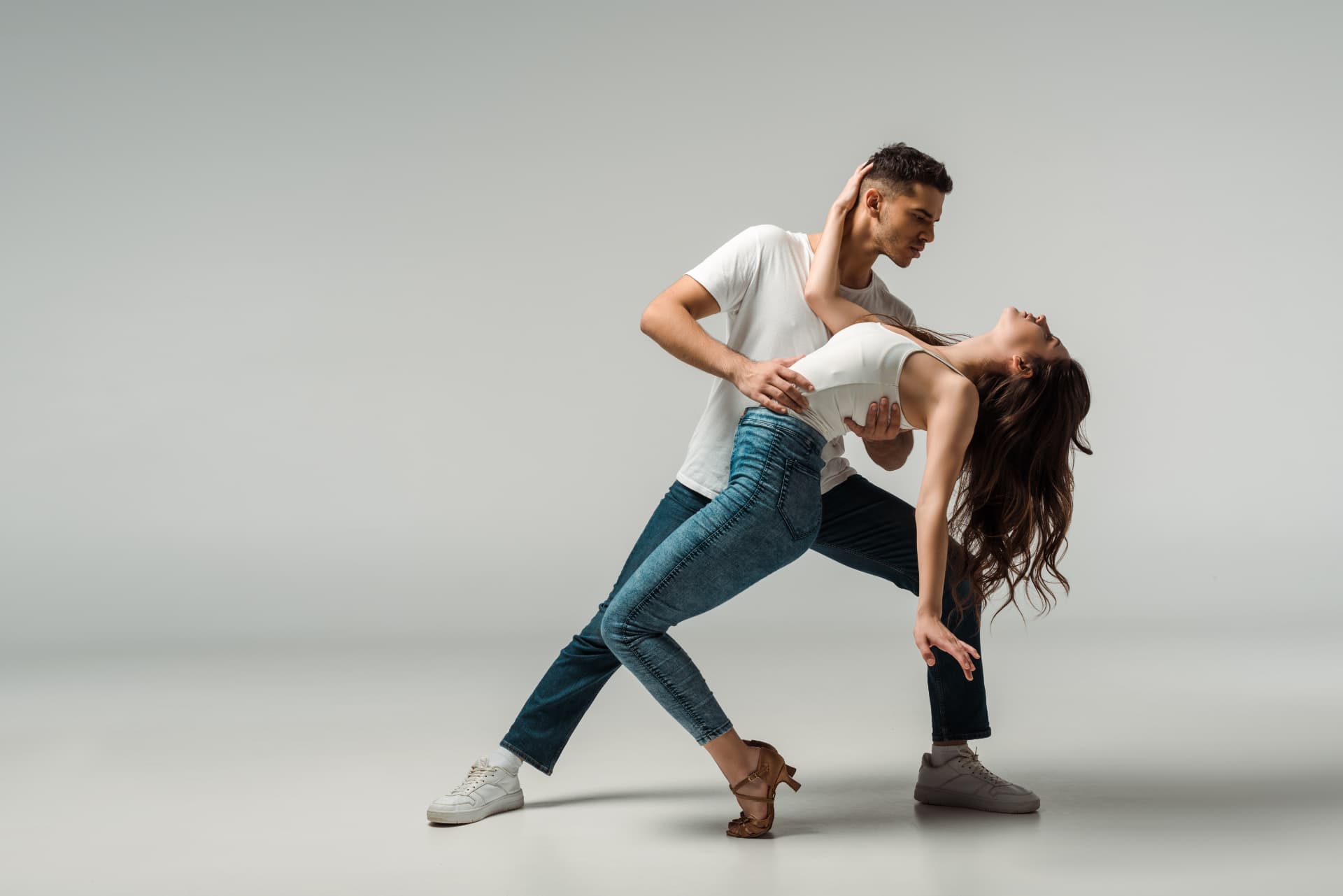 Ζευγάρι που χορεύει salsa σε φωτεινό στούντιο